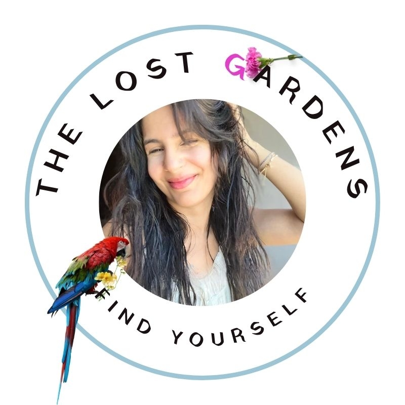 Smiling woman in a circular logo with a parrot and flower, titled "The Lost Gardens—Find Yourself."